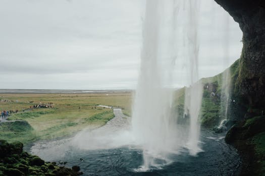 Capture of a waterfall in Iceland surrounded by a lush, green landscape, perfect for travel inspiration.