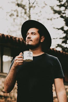 Young man with coffee cup, enjoying a relaxed moment outdoors in Mazamitla, Mexico.