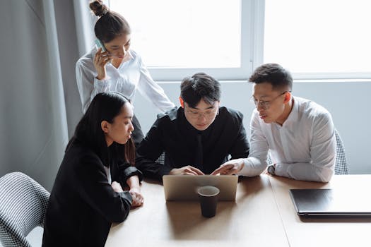 Business team brainstorming in an office setting with laptops and teamwork spirit.