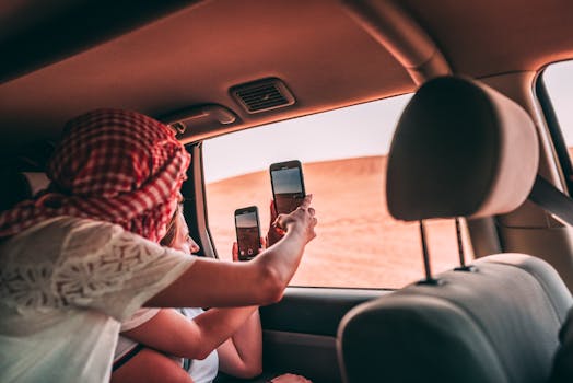 Tourists taking photos from inside a car in Dubai's desert landscape.