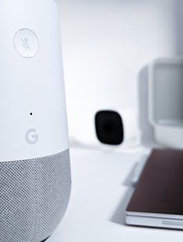 Close-up of a smart speaker on a desk with modern gadgets in a sleek setting.